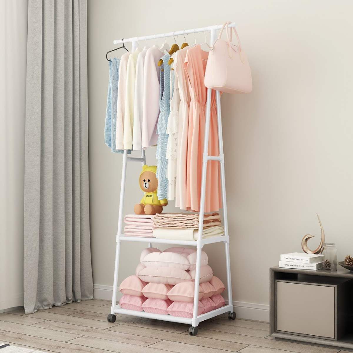 Kledingrek verrijdbaar wit met kleding en handdoeken in slaapkamer